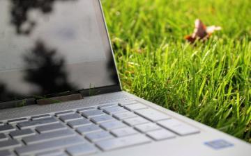 open laptop computer on a lawn of green grass