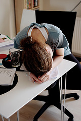 Young woman with her head down on her desk image link to story