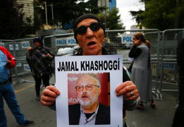 Activist holding poster with photo of missing Saudi journalist Jamal Khashoggi (AP Images/Lefteris Pitarakis). image link to story