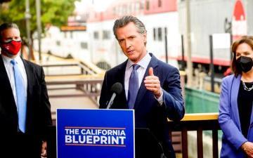 California Governor Gavin Newsom discusses his budget proposal, dubbed the California Blueprint, on Thursday, Jan. 13, 2022, in Santa Clara, Calif. Santa Clara Mayor, Lisa Gilmor, on far right. AP Photo-Noah Berger image link to story