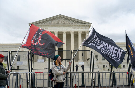 Abortion-rights protesters wave flags during a demonstration outside of the U.S. Supreme Court, Sunday, May 8, 2022, in Washington. (AP Photo/Gemunu Amarasinghe) image link to story