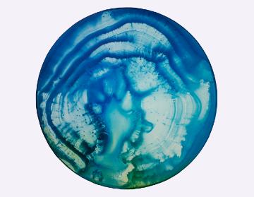 Abstract blue and green circular art resembling a planets surface.