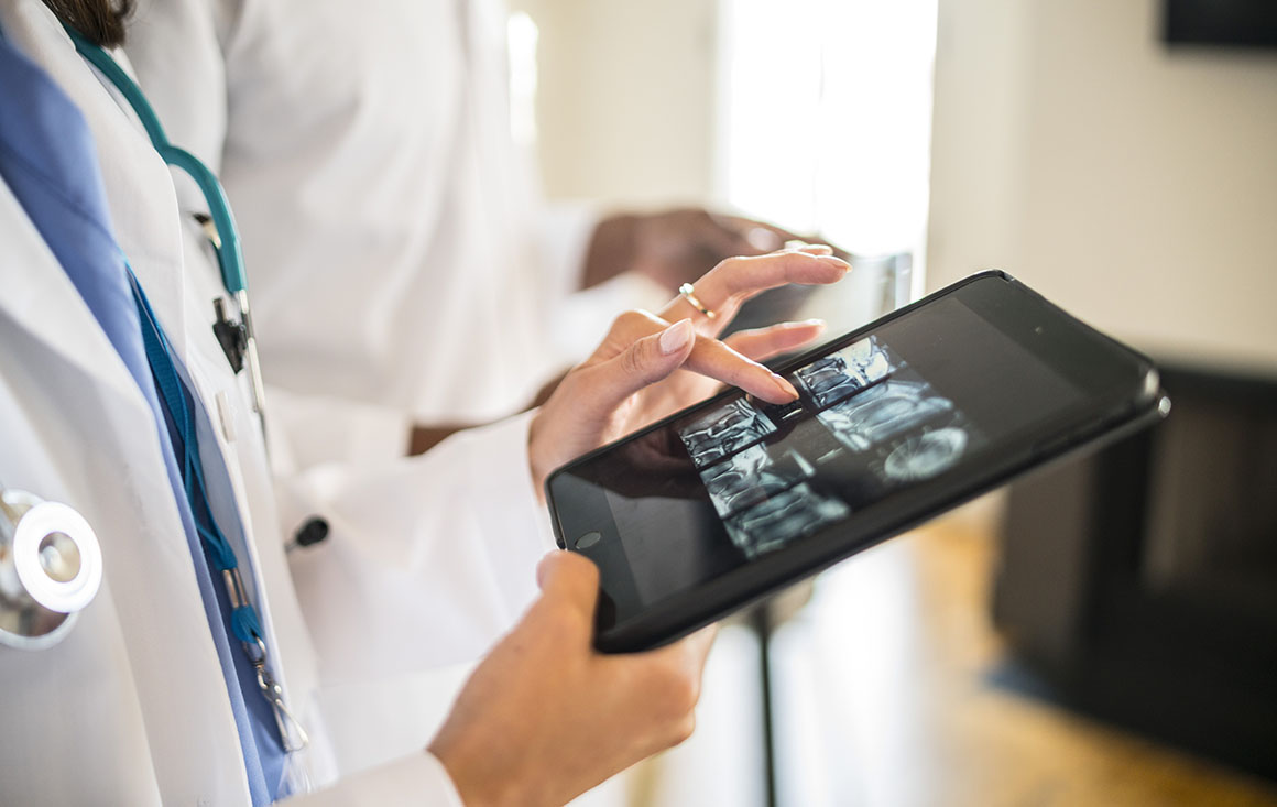A doctor uses a tablet to look at medical images.