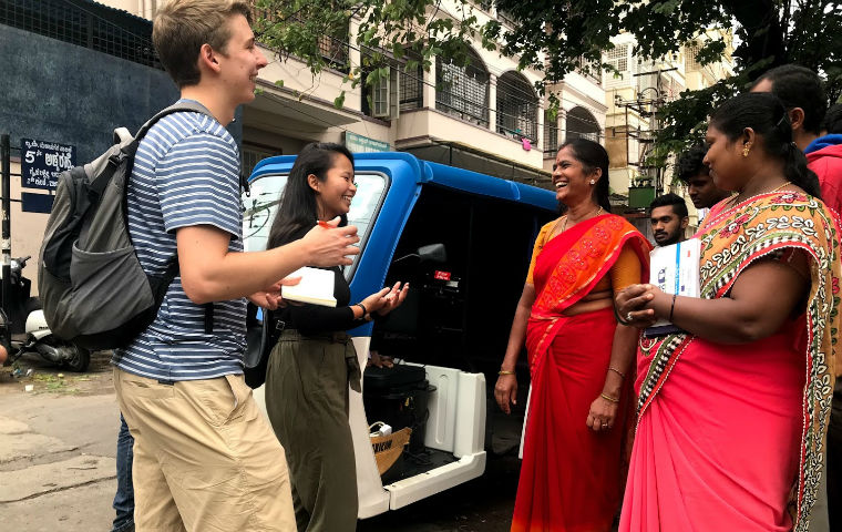 GSBF fellows smiling with women wearing red saris image link to story