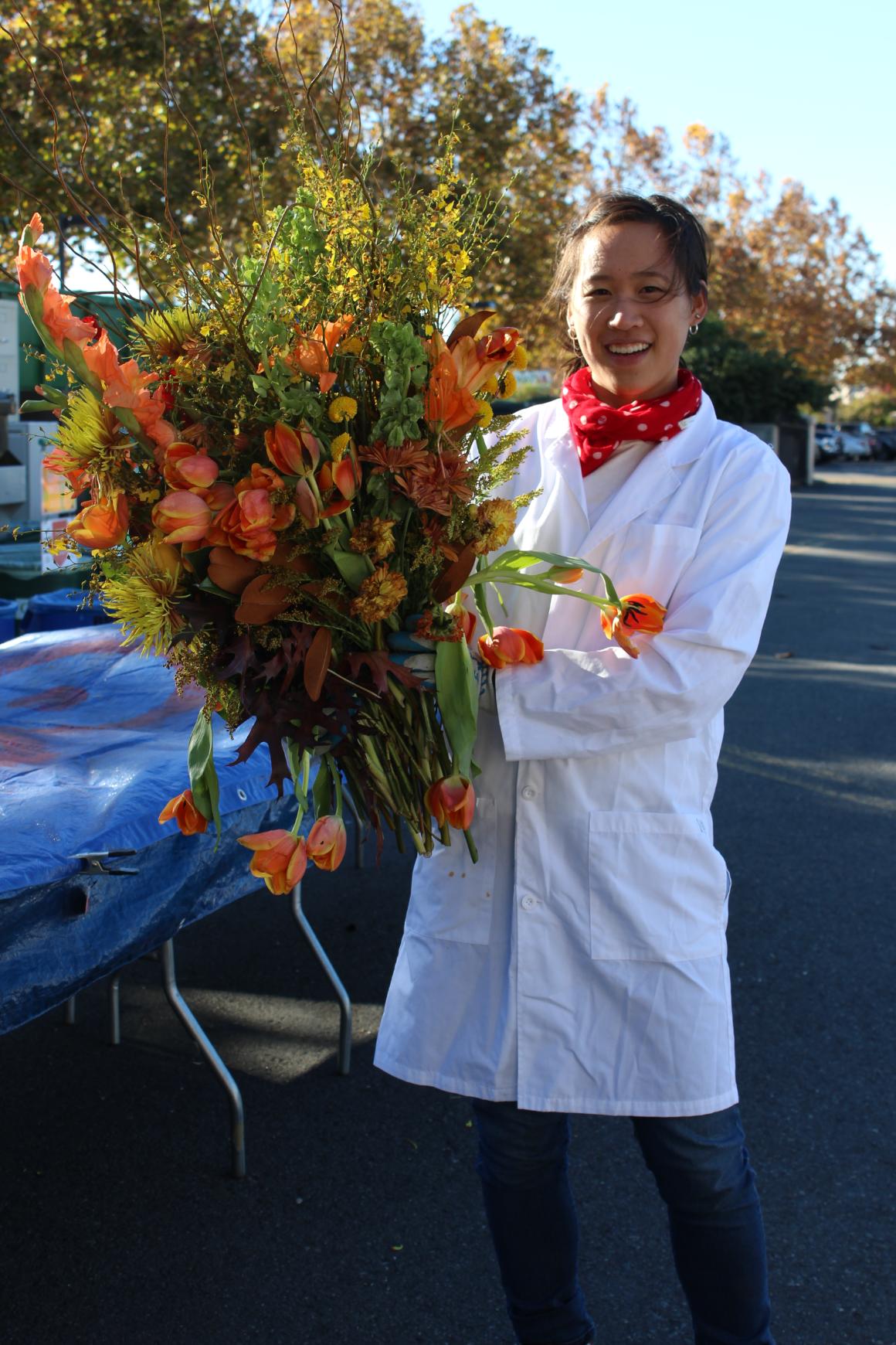 Sustainability Coordinator (Cara) with flowers found at a waste characterization