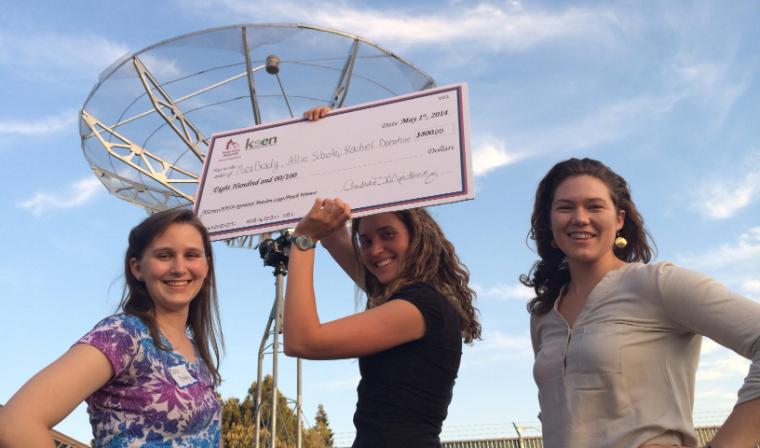 Three female students show off their big check as winners of the SporeSat Challenge