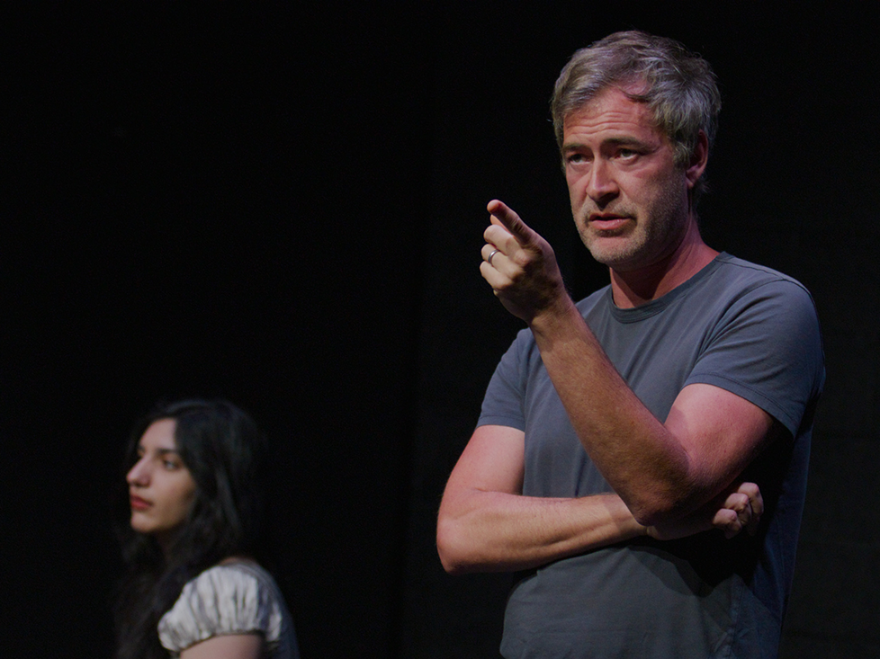 Mark Duplass lecturing in a dark theatre image link to story