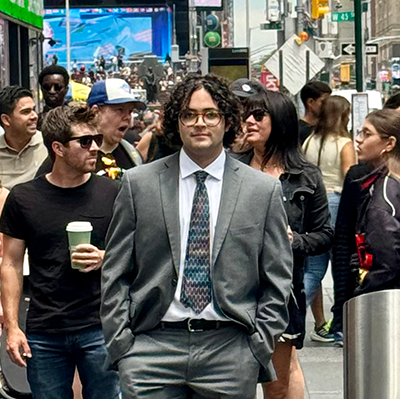 Adrian Machado at a cross walk with many others.