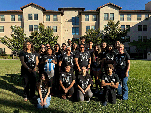 Amy Lueck with Muwekma Ohlone elders and youth on the grass outside Sobrato Hall