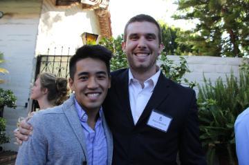 Two men smiling at an outdoor awards event. 