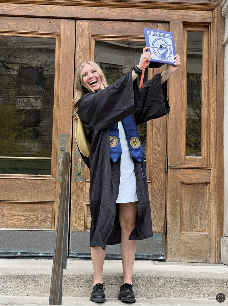 Skyler Kriese in her graduation gown holding her cap.