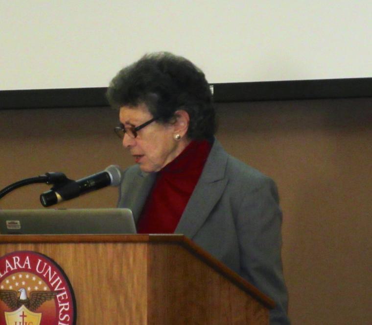 A person speaks at a podium with a microphone.