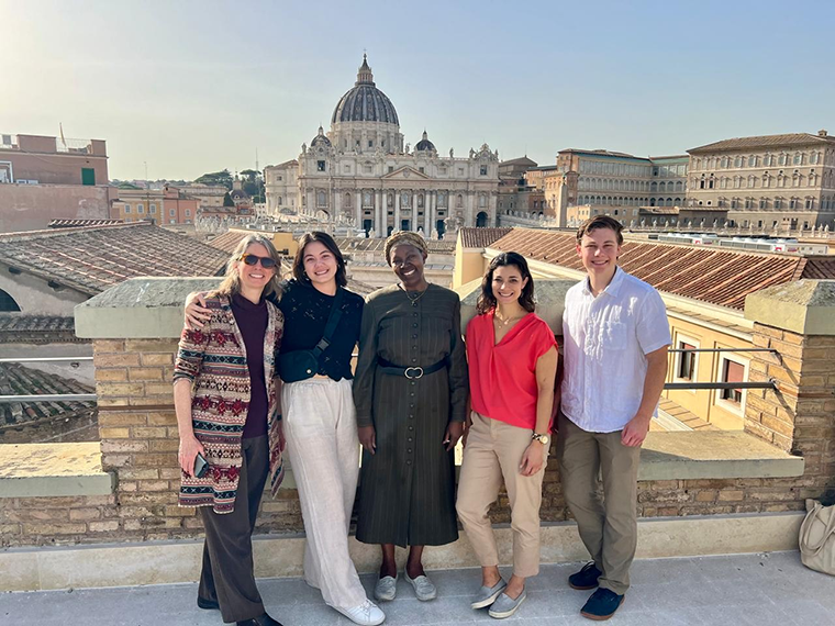 Group photo with cathedral in the distance, in the city of Rome.