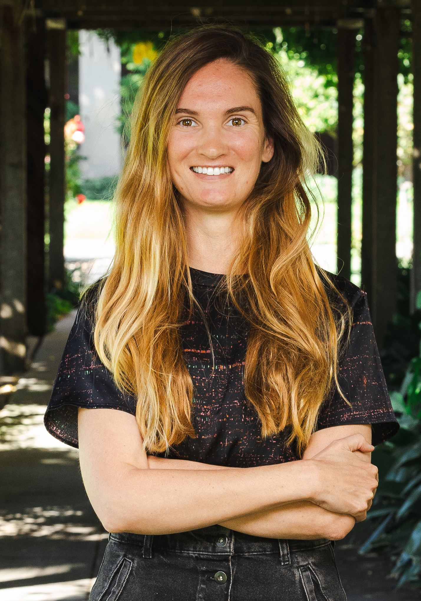 Woman smiling at camera with arms crossed