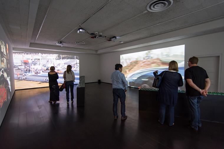 Visitors in a gallery watching video projections.