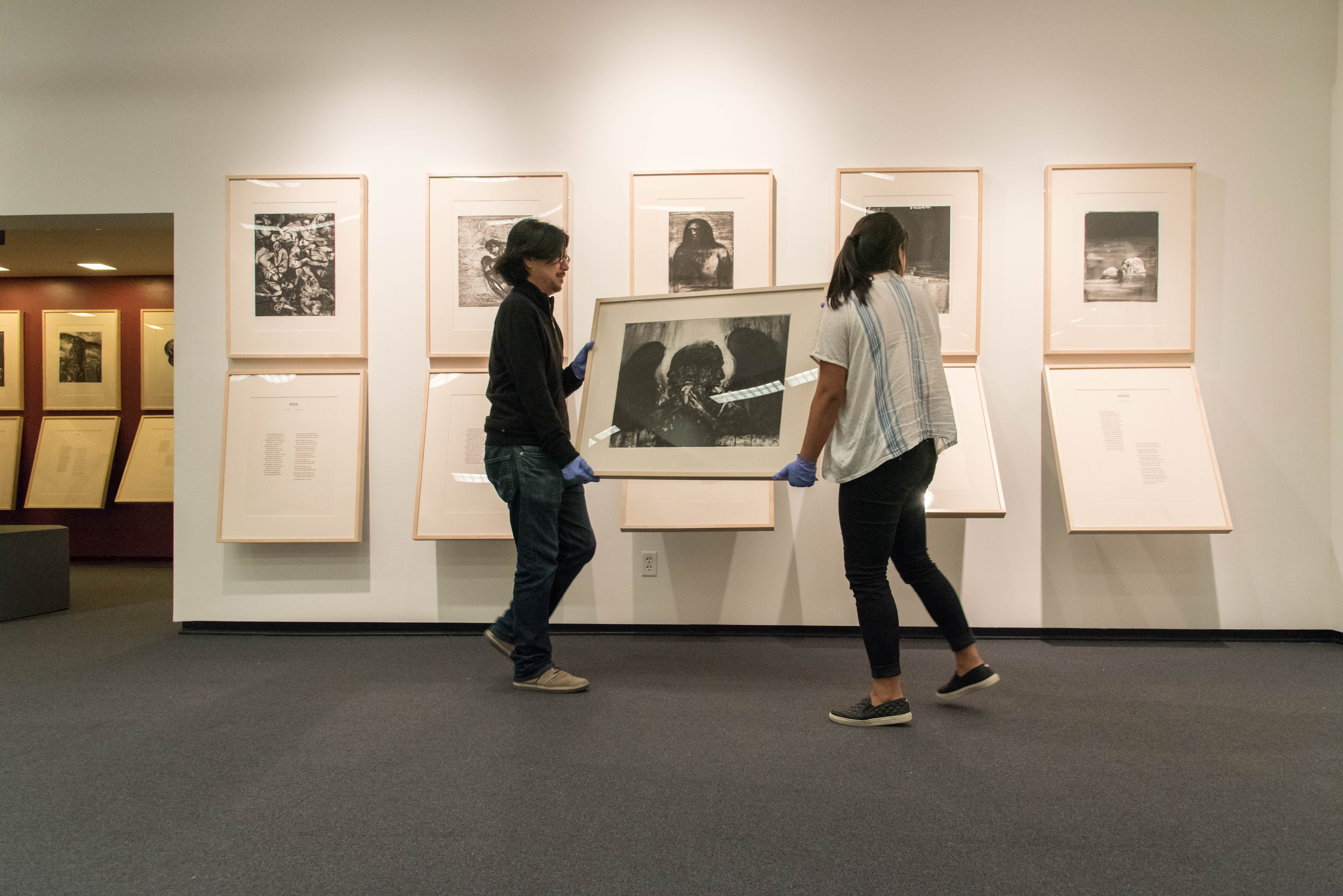 two people carrying a framed artwork