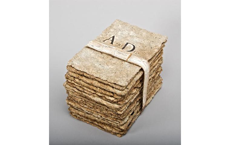 Artwork created from pulped dictionary pages arranged in stack with band holding them together