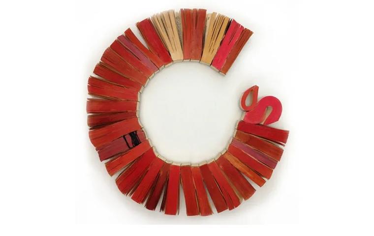 Wall sculpture created from red book ends arranged in open circle
