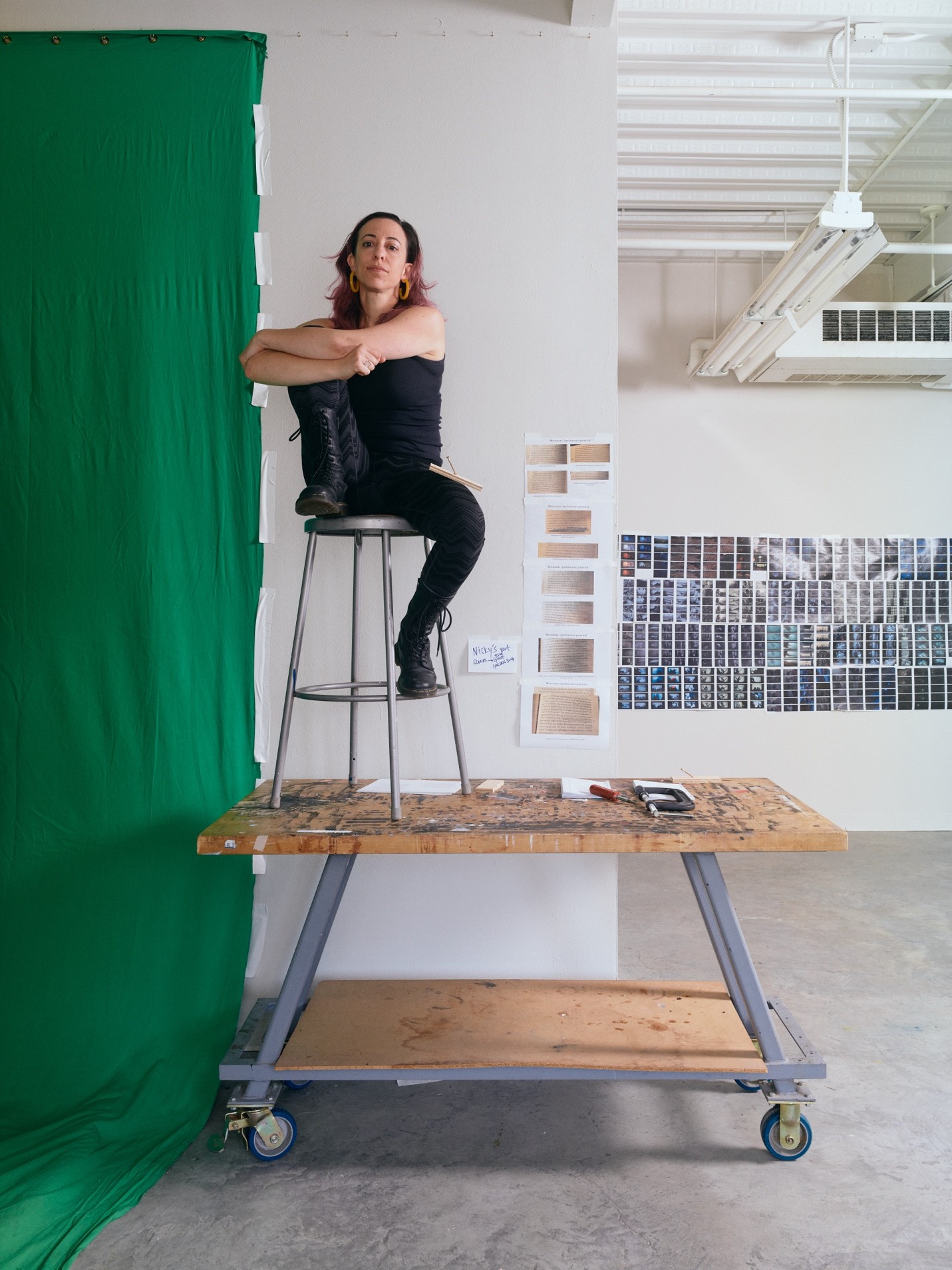 Picture of woman seated on stool on top of structure