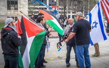 Two groups of protesters carrying Palestinian and Israeli flags facing off during an outdoor protest. Photo by Ted Eytan 2017.03.26 Anti-Israel Protest, Washington, DC. Used with permission under Creative Commons license CC BY-SA 4.0.