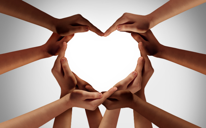 Ten hands form a heart representing the Santa Clara University three C's: Competence, Compassion, and Conscience.  Photo by wildpixel / Getty Images via Canva for Education