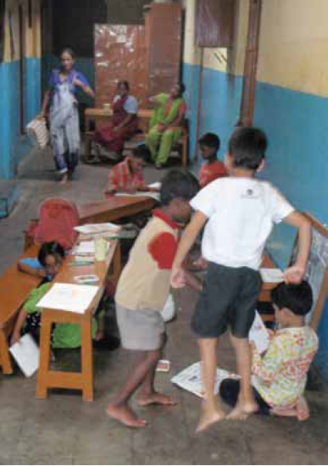 Children studying and playing in a narrow, colorful indoor space.