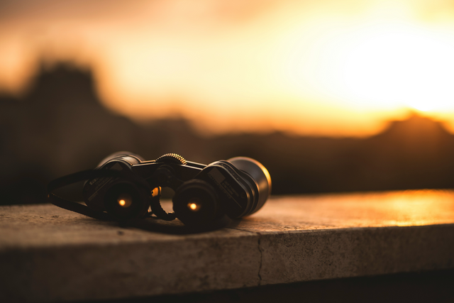 Binoculars pointing to a sunset 