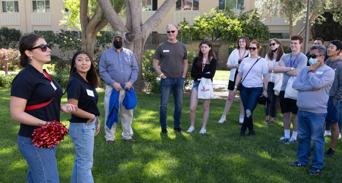 Campus tour guides speak to a group of parents and future students 