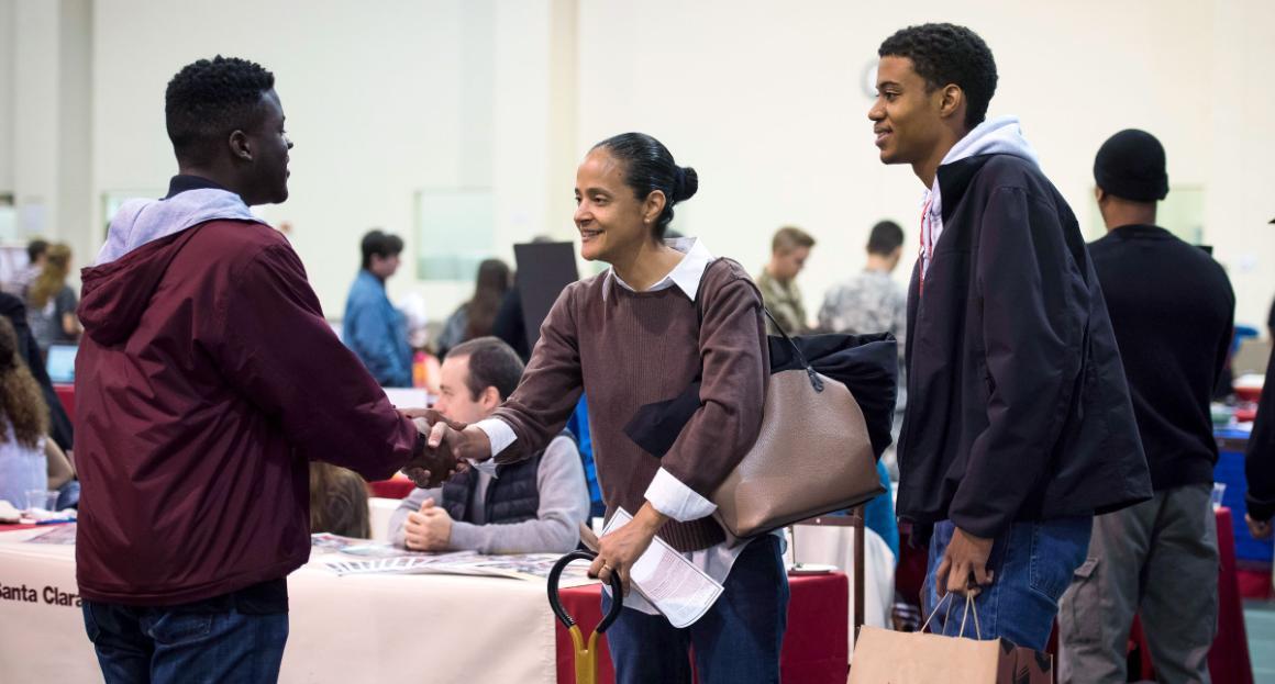 A parent and student shake hands with an SCU counselor 