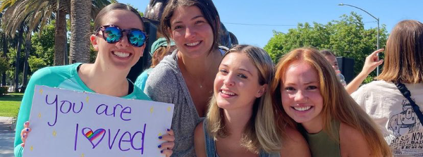 Students holding a sign that reads, you are loved!