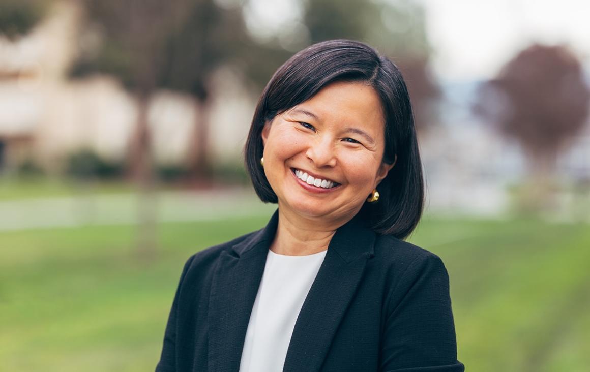 Ms. Kimura-Walsh smiles for a photo wearing a white blouse and black jacket.