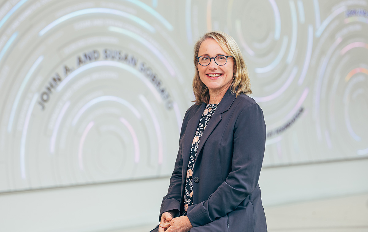 Kendra Sharp sits in front of the gray donor wall in SCDI