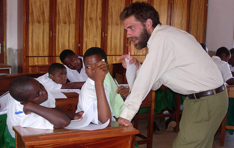 Michael Neumann teaching in a classroom in Tanzania during his time as a Peace Corps Volunteer.
