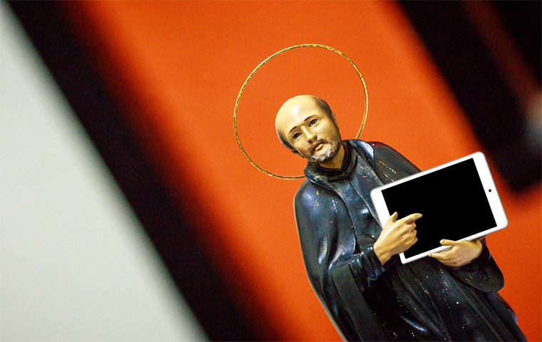 A figurine of a religious person holding an iPad