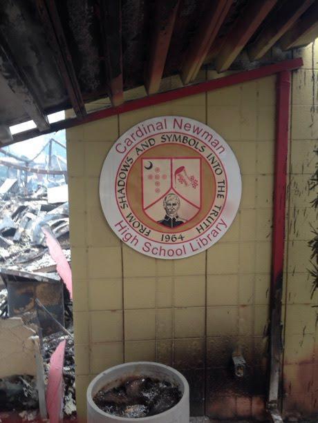The Cardinal Newman seal affixed to a standing wall in the fire wreckage
