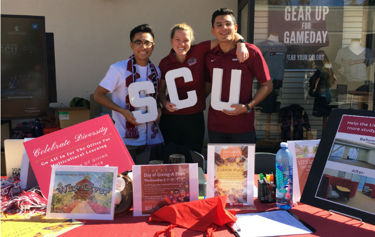 Students posing with SCU signs for Day of Giving image link to story