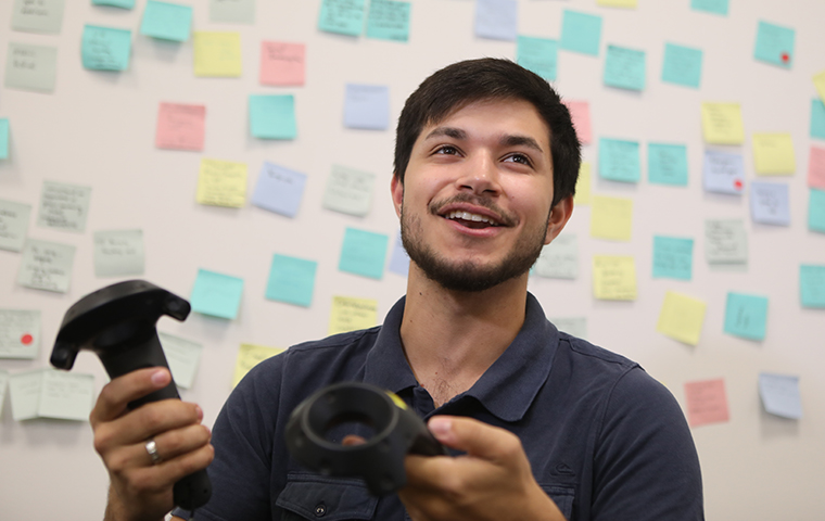 Miles Elliott '19 holds two virtual reality controllers image link to story