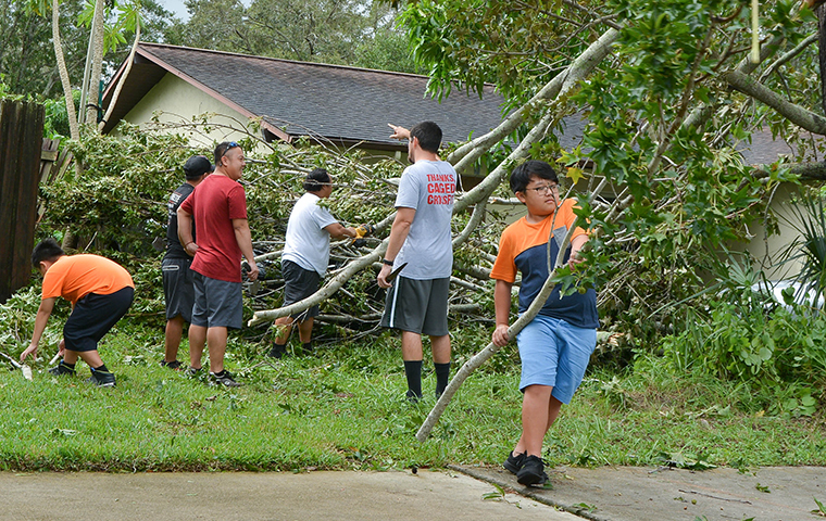 A boy and his family clean up debris in Largo, Florida following Hurricane Irma.