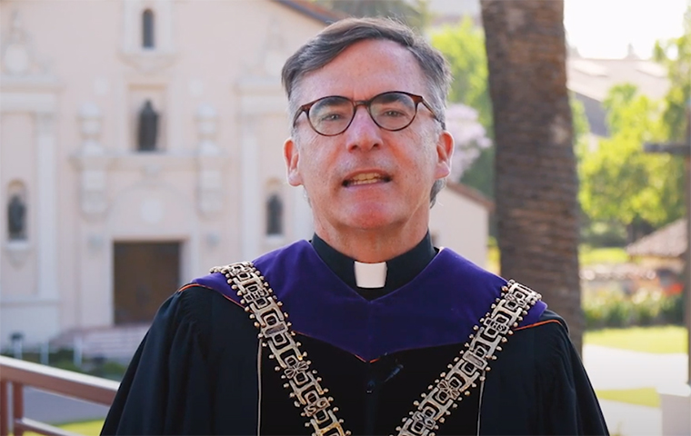 President Kevin O'Brien stands in front of the Mission Church in regalia