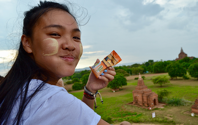 Athena Nguyen looking off a mountain holding a pack of crackers