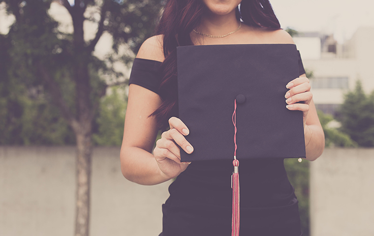 Student holding mortar board image link to story