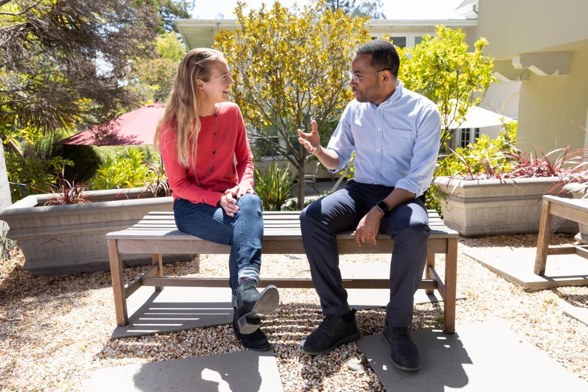 Two students speaking in an outdoor courtyard