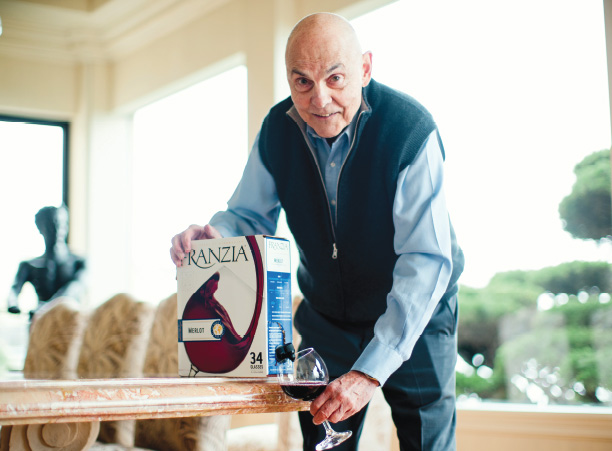 Man displaying a decorated wine box indoors.