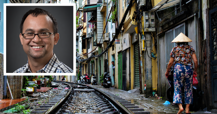 SCU Leavey professor Long Le headshot in front of a photo of Vietnam