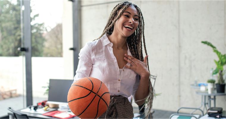 A cheerful young businesswoman having fun with ball in office take a break