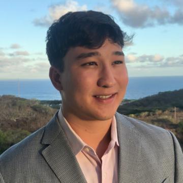 A person in a suit with an ocean view background.