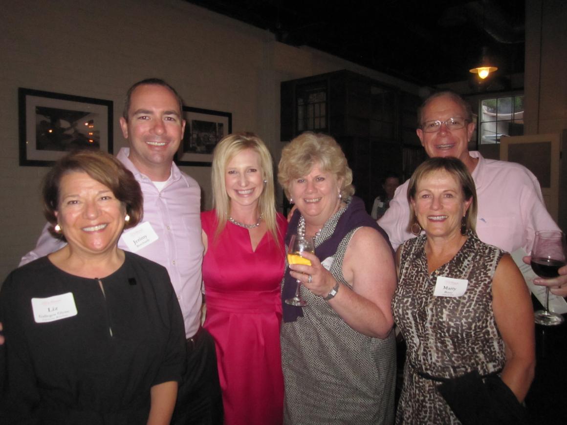Six people posing at an event, three holding awards.