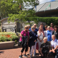 A group of people in casual clothing standing together in front of the Ashland, OR Shakespeare Festival Theatres
