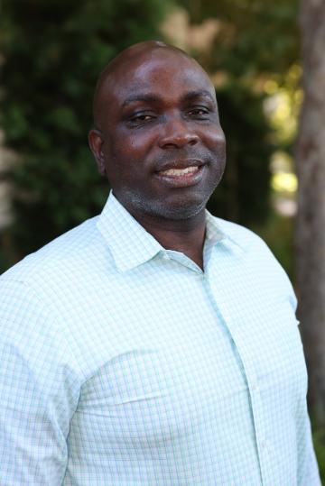 A man in a light-colored shirt, smiling