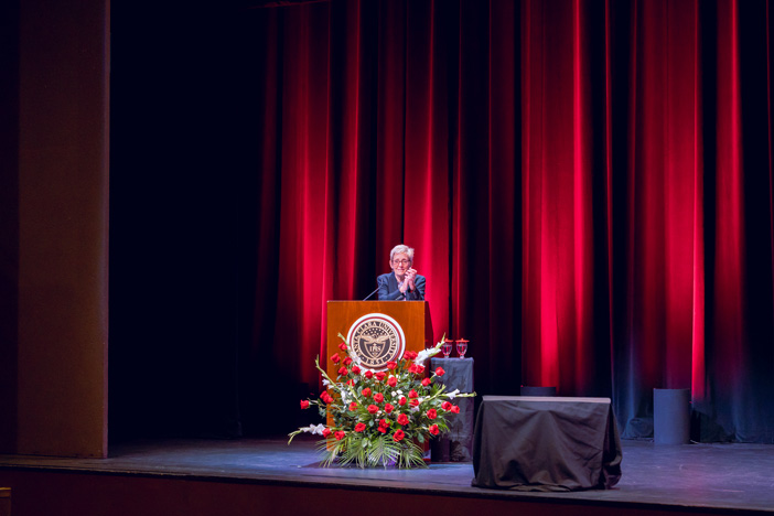 President Sullivan at a podium with a SCU seal, addressing an audience